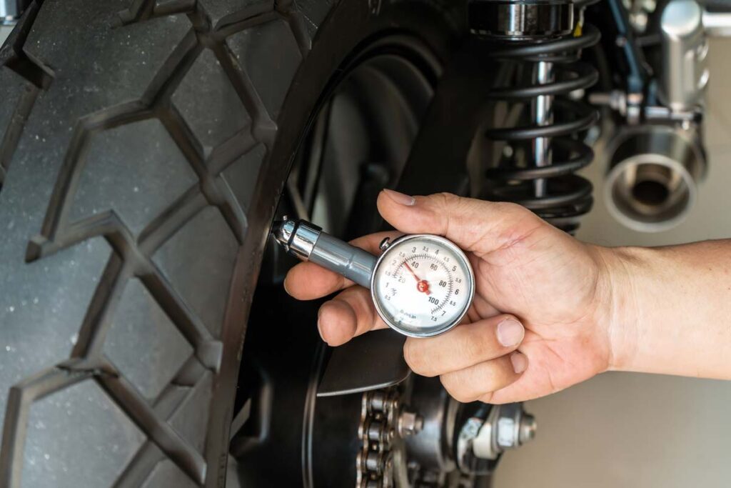 Checking the air on a motorcycle tire