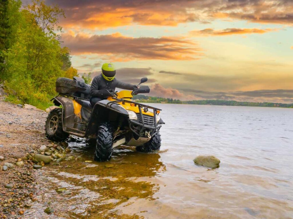 Man on a quad on the riverbank